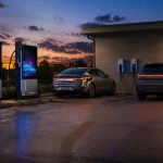 Commercial EV charging station with two DC fast chargers and two Level 2 chargers at dusk